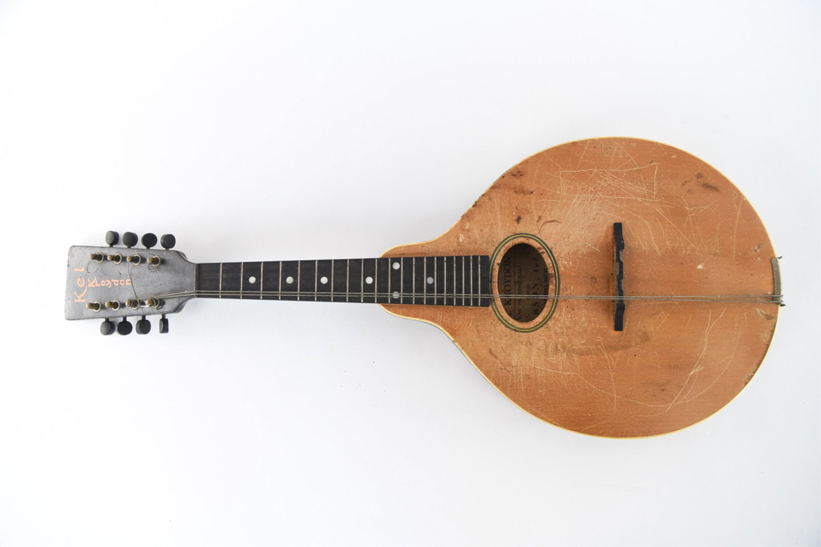 KEL KROYDON MANDOLIN: By Gibson. Dimensions: H 26.25" x W 10.25" x D 2.25" Condition: Some strings broken, scratches, finish wear. Overall signs of age and use.