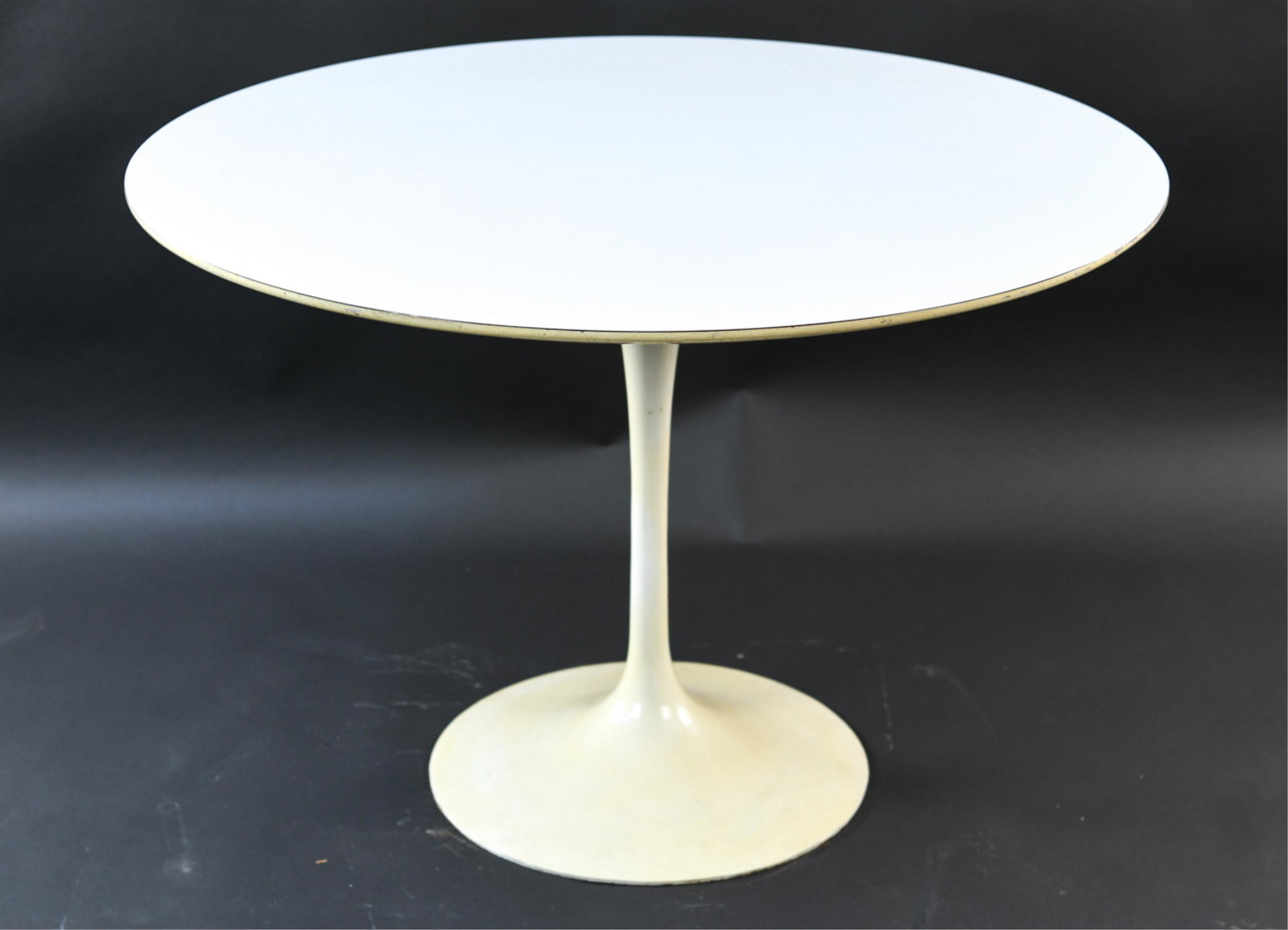 EERO SAARINEN FOR KNOLL TULIP TABLE: C. 1970. Tagged under top. Dimensions: H 29" x D 42" Condition: Needs hardware to secure top to base. Showing wear consistent with age and use.