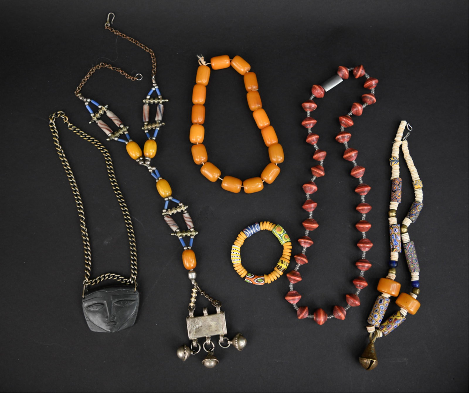 GROUPING OF ETHNIC NECKLACES: Including trade beads, bakelite, silver, brass, slate etc. Dimensions: L 21" Condition: Showing signs of use and age, bakelite barrel beads need restrung.