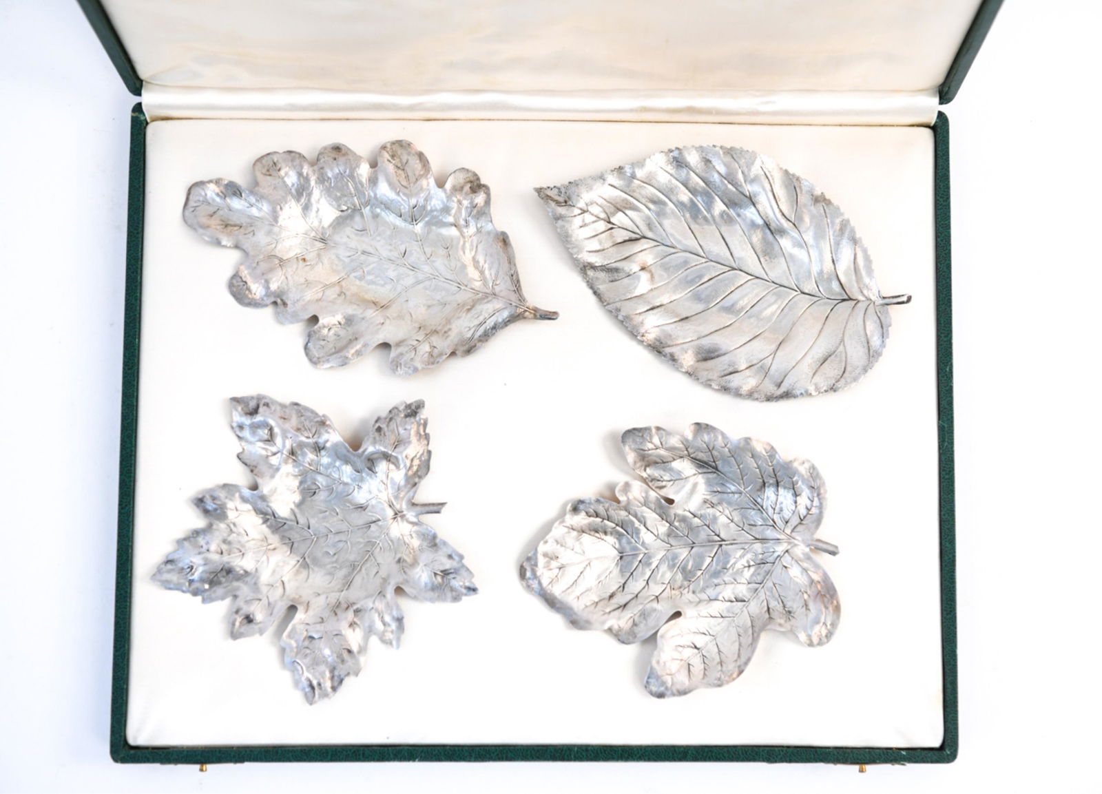 (4) PAUL E. FLATO STERLING SILVER LEAVES: DESCRIPTION UPDATED SHORTLY Case labeled; 576 5th Ave New York. 4 different leaves in case. Marked sterling. Dimensions: (Largest leaf) W 6" x D 3.5" Weight: Condition: Minor tarnishing.