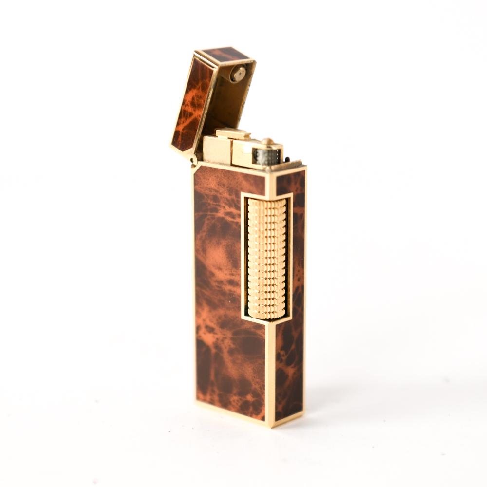 DUNHILL ROLLAGAS FAUX TORTOISE LIGHTER IN BOX: Faux tortoise and gold plate. Fully marked. In box with paperwork. Dimensions: (Lighter) H 2.5" x W 1" x D .5" Condition: Non-functional. Otherwise clean.