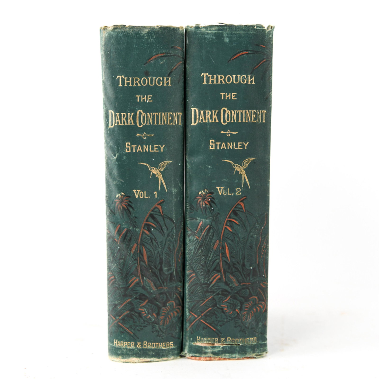 HENRY M. STANLEY THROUGH THE DARK CONTINENT 1878: Two volumes. Published Harper Brother, New York, 1878. Decorative cloth covers. Includes large fold out map. Dimensions: H 9" x W 6" Condition: Covers with wear. Spines broken. Water staining to tops 