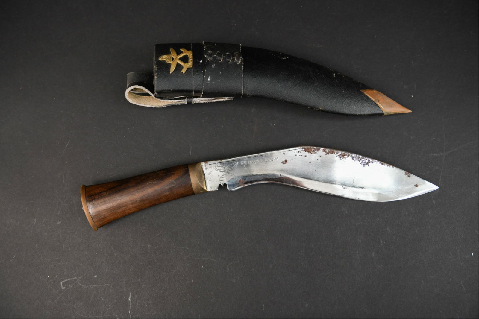 KUKRI KNIFE: Marked Nepal on sheath crest. Marked Gurkha Army on blade. Dimensions: (Sheathed) H 17.25" x W 3" Condition: Showing wear consistent with age and handling. Some areas with surface rust on blade. Marks