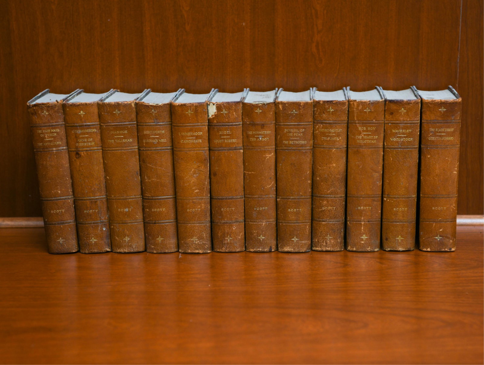 ANTIQUE SET WALTER SCOTT WORKS: (12) volumes. Half leather bound. Published John W. Lovell, New York. Dimensions: H 7.5" x W 5" Condition: Some edge chipping to binding. Look internally complete. Uncollated.