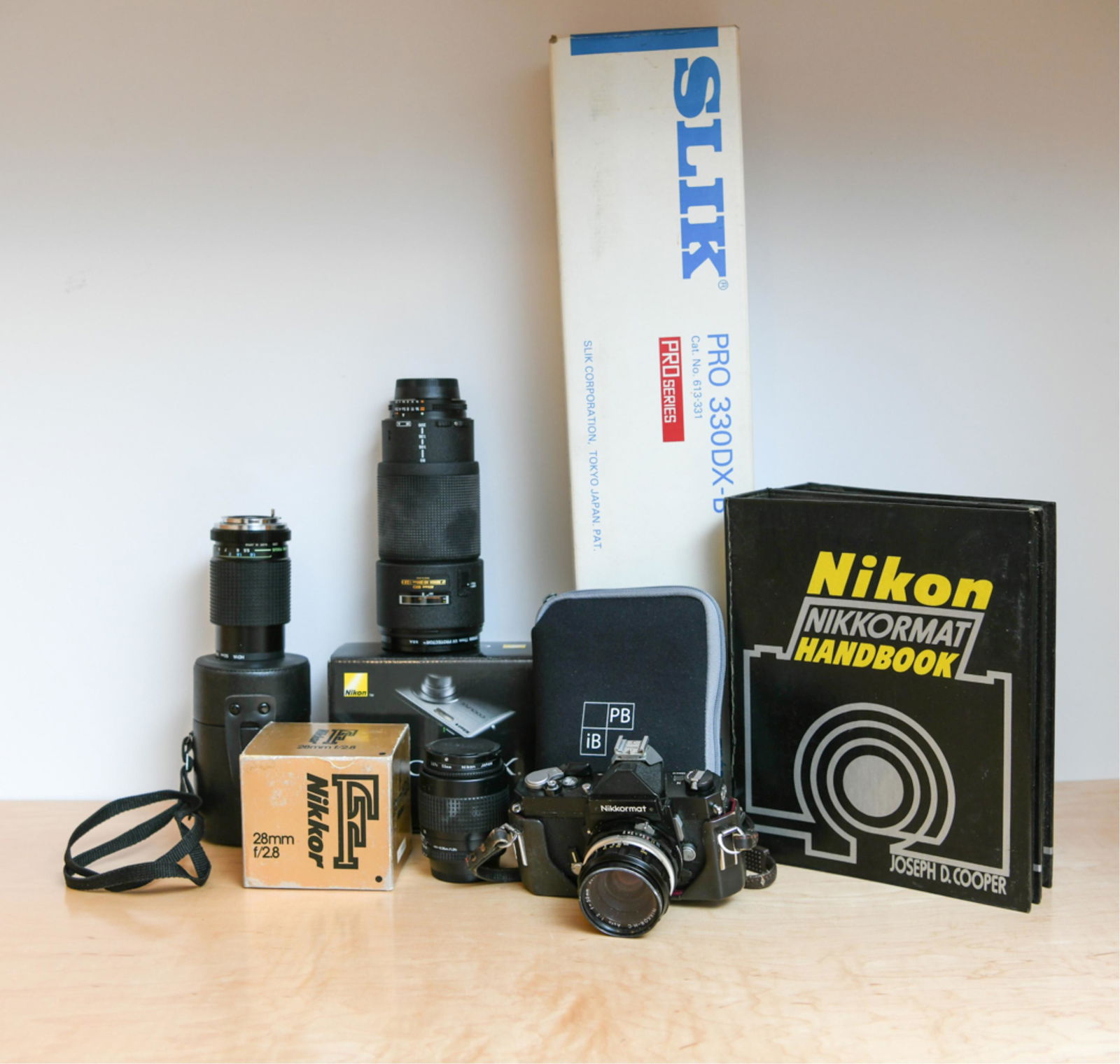 GROUPING OF CAMERA EQUIPMENT: Including Nikon AF Nikkor 80-200 mm telephoto lens, Nikkormat SLR camera, Nikon handbooks, more Nikon lenses, etc. Dimensions: (Tripod box) L 24" Condition: As found, untested.