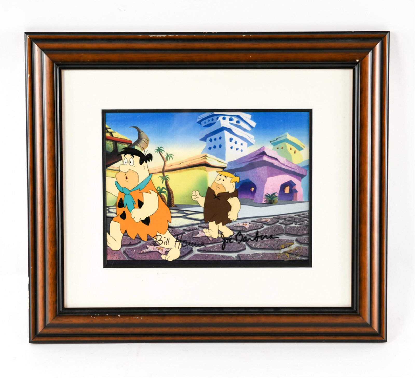 FLINTSTONES PRODUCTION CEL HANNA BARBARA SIGNED: Fred & Barney hand painted cell signed by Bill Hanna and Joe Barbara, with studio certification stamp. Dimensions: (Frame) H 18.5" x W 21.5", (Sight) H 9" x W 12" Condition: Some rubbing to frame.
