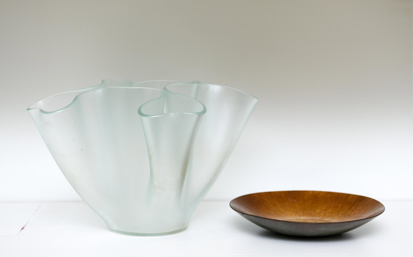 MID-CENTURY DISH & VASE: Golden enamel over copper dish, unmarked. Textured ribbon handkerchief vase, unmarked. Dimensions: (Vase) H 6.5" x W 10" x D 10.5" Condition: No issues to note.