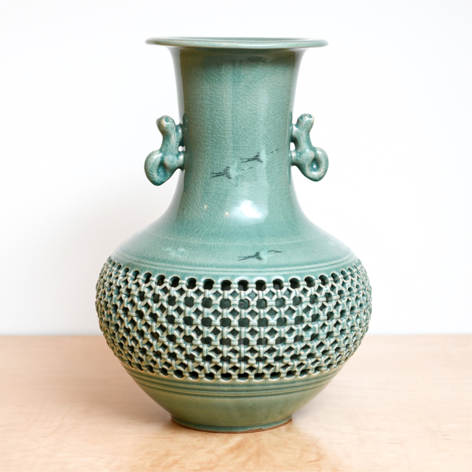 CONTEMPORARY KOREAN CELADON VASE: With reticulated detail. Signed underneath. Dimensions: H 14" x Dia. 9" Condition: Small flaw on rim.