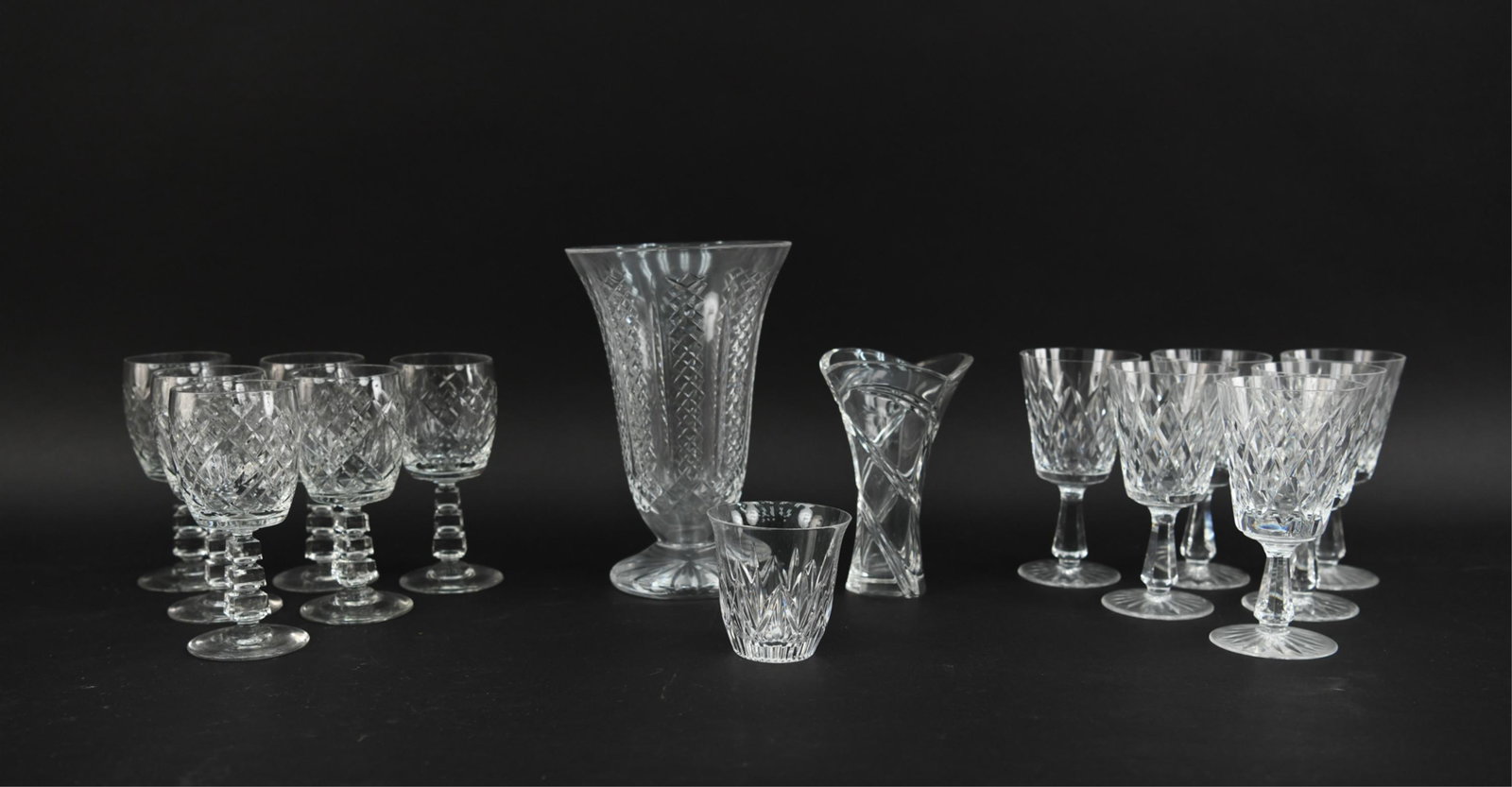(15) GROUPING OF GLASS: This grouping includes (2) vases, (2) sets of 6 wine glasses and 1 small drinking glass. Dimensions: (Largest) H 10" x D 6.5" Condition: Used. Showing light signs of wear, some with light surface scra
