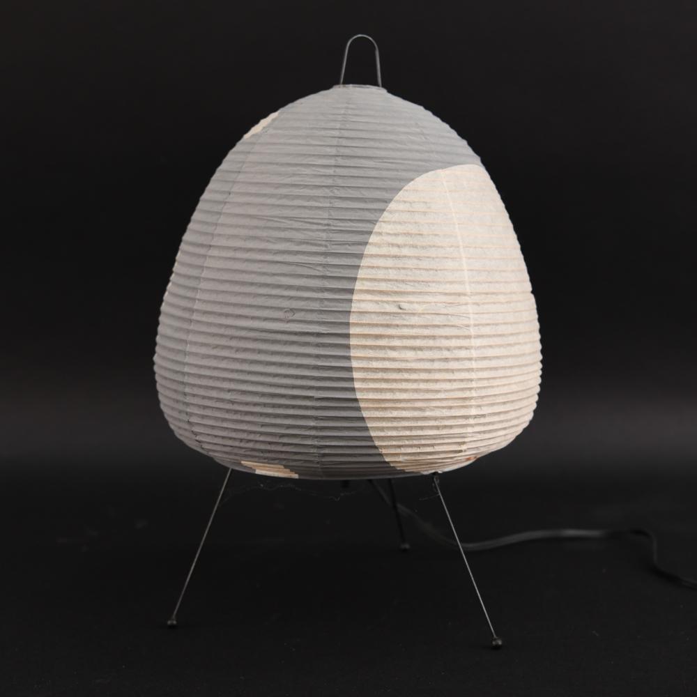 ISAMU NOGUCHI AKARI PAPER SHADE LAMP: Marked on shade. Dimensions: H 15.75" x D 9.5" Condition: Showing some signs of age and use including a couple small punctures to shade.