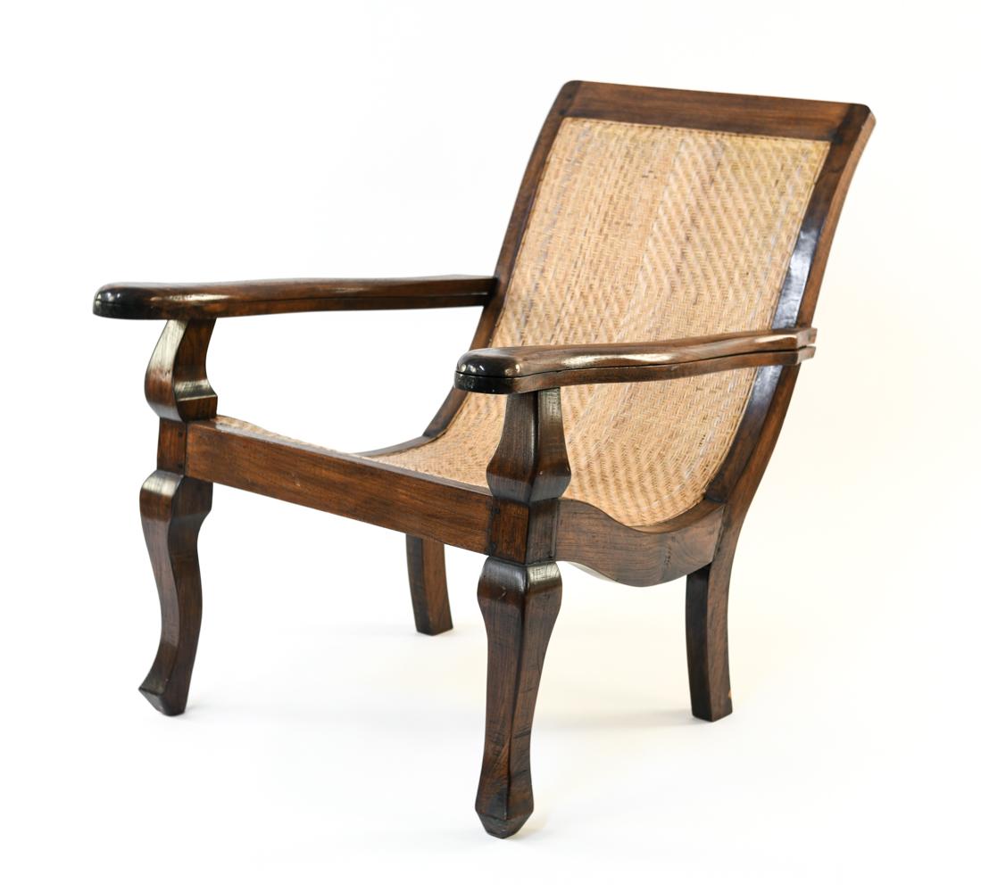 CANED PLANTATION LOUNGE CHAIR: Dimensions: H 35.5" x W 29.5" x D 39" S.H. 18" Condition: Few cracks to caning. Wear consistent with age and use.