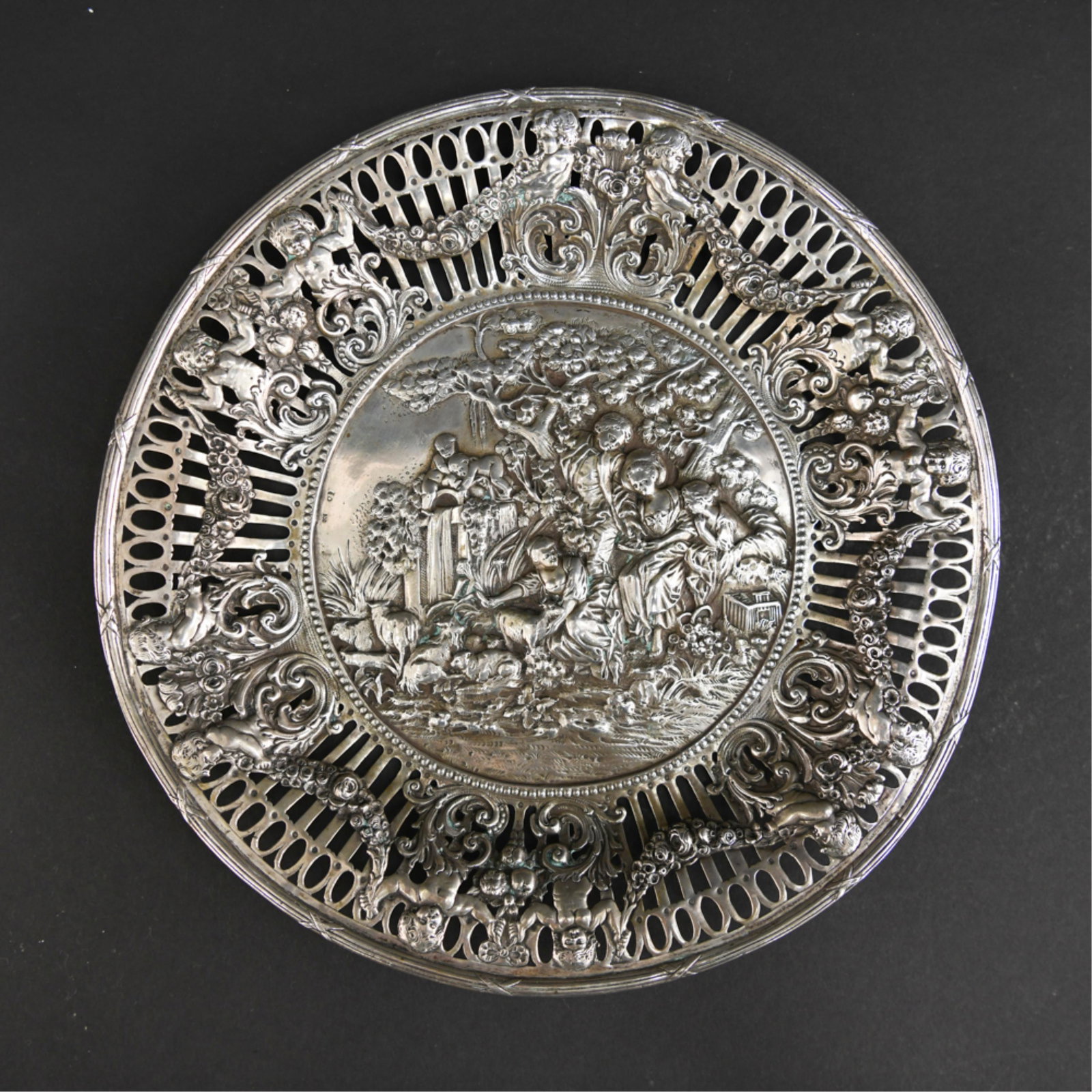 .800 SILVER REPOUSSE PICTORIAL PLATE: Hallmarked .800 with repousse putti. Dimensions: H 1" x Dia: 10.5" Weight: 15 ozt Condition: Showing normal signs of use.