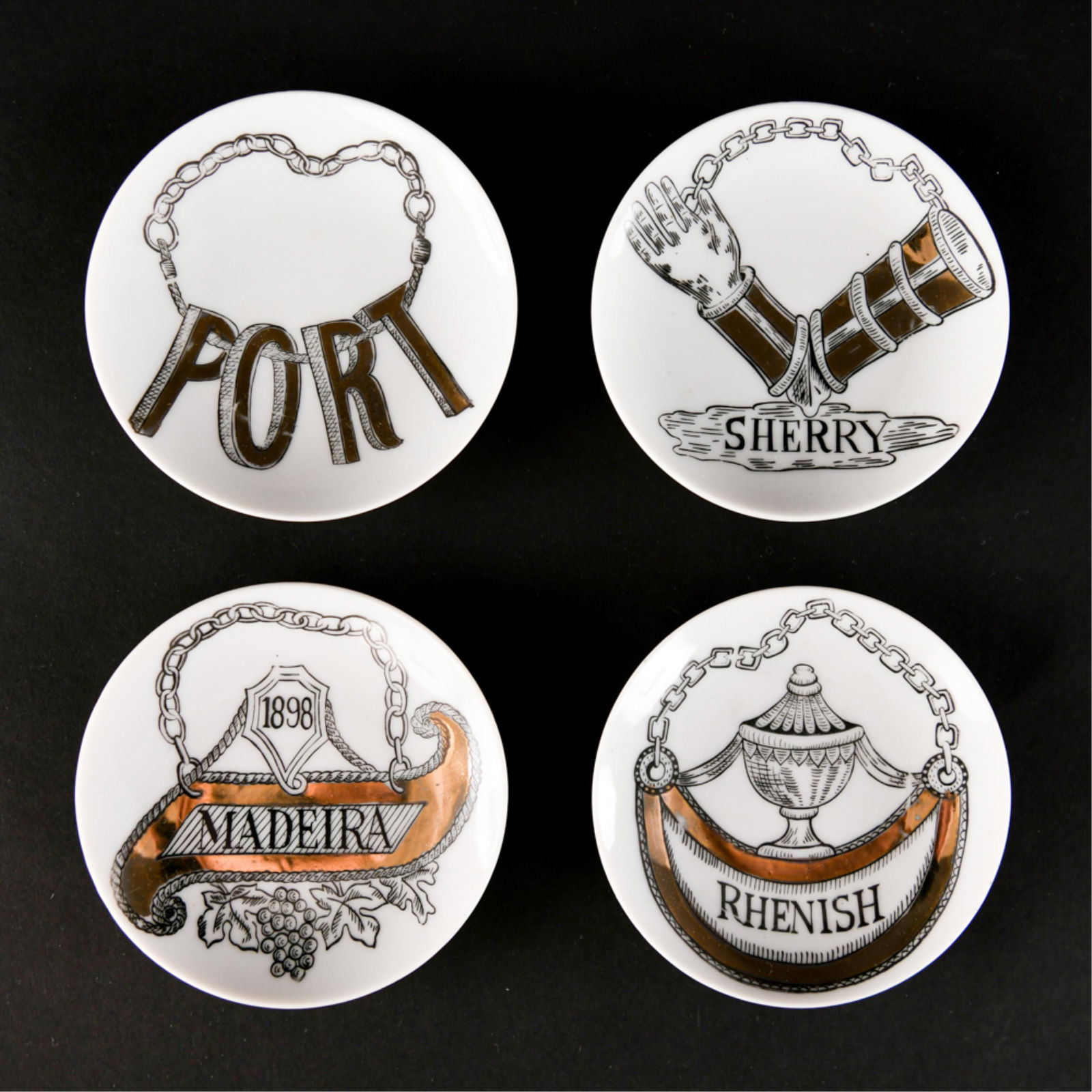 STYLE OF FORNASETTI PORCELAIN LIQUOR DISHES: Decal on bottoms. Dimensions: (Each) D 4.25" Condition: Wear consistent with age and handling.