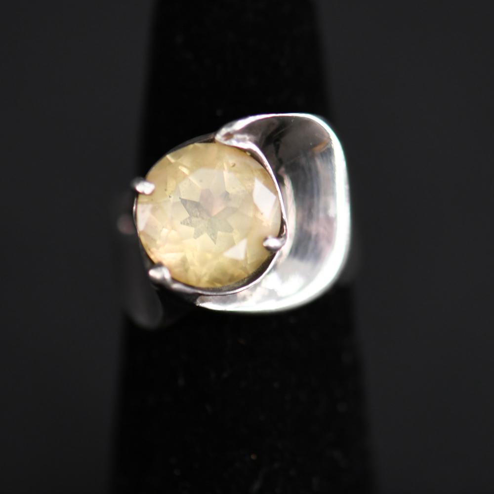 SCULPTURAL MODERN STERLING SILVER RING: Nicely sculpted sterling silver with a yellow glass stone. Dimensions: Face: 0.75" Ring Size: 5 Condition: Showing signs of use and age.