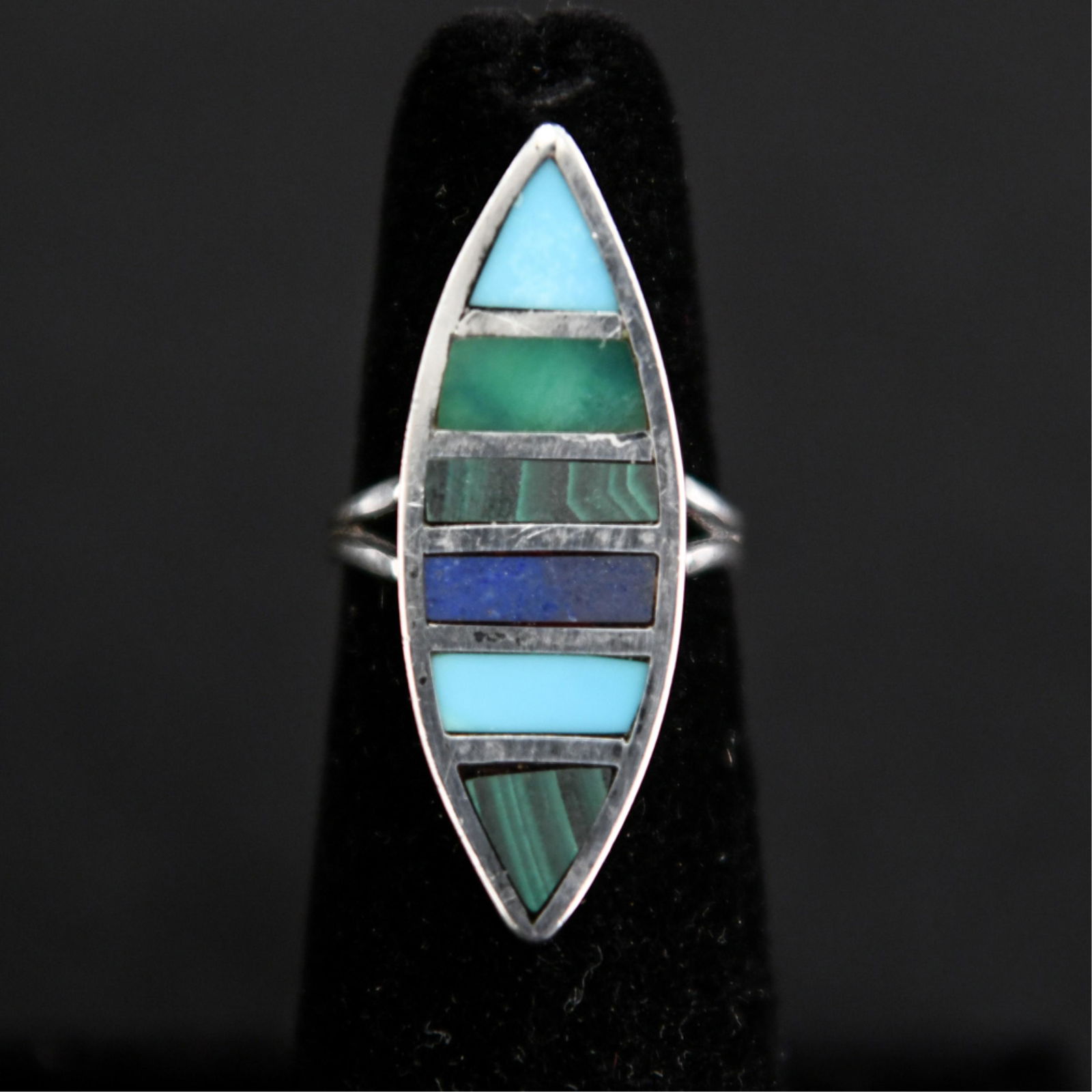 NATIVE AMERICAN INLAID STONE STERLING SILVER RING: Hallmarked JP, consists of inlaid turquoise, malachite, and lapis lazuli. Dimensions: Face: 2.5" Ring Size: 5 Condition: Showing light signs of use and age.