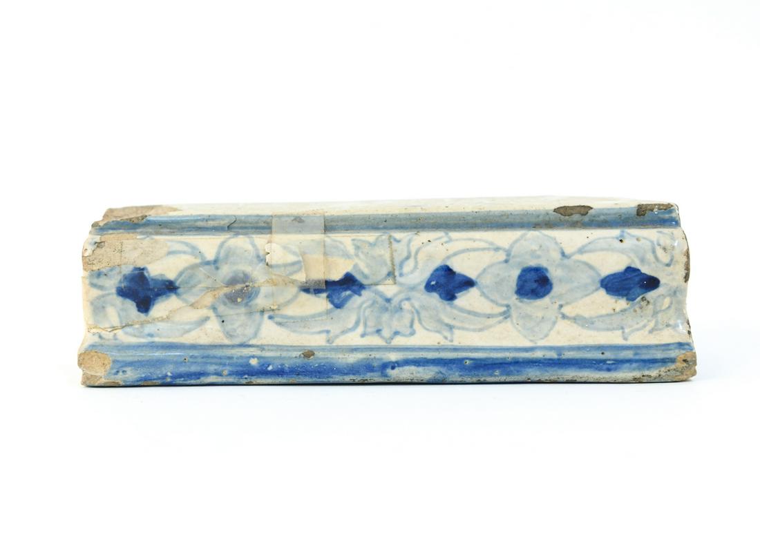 ANTIQUE DELFT SHAPED TILE: For top railing. Dimensions: L 8.5" x W 2" x D 2" Condition: Chips taped on and other chipping.