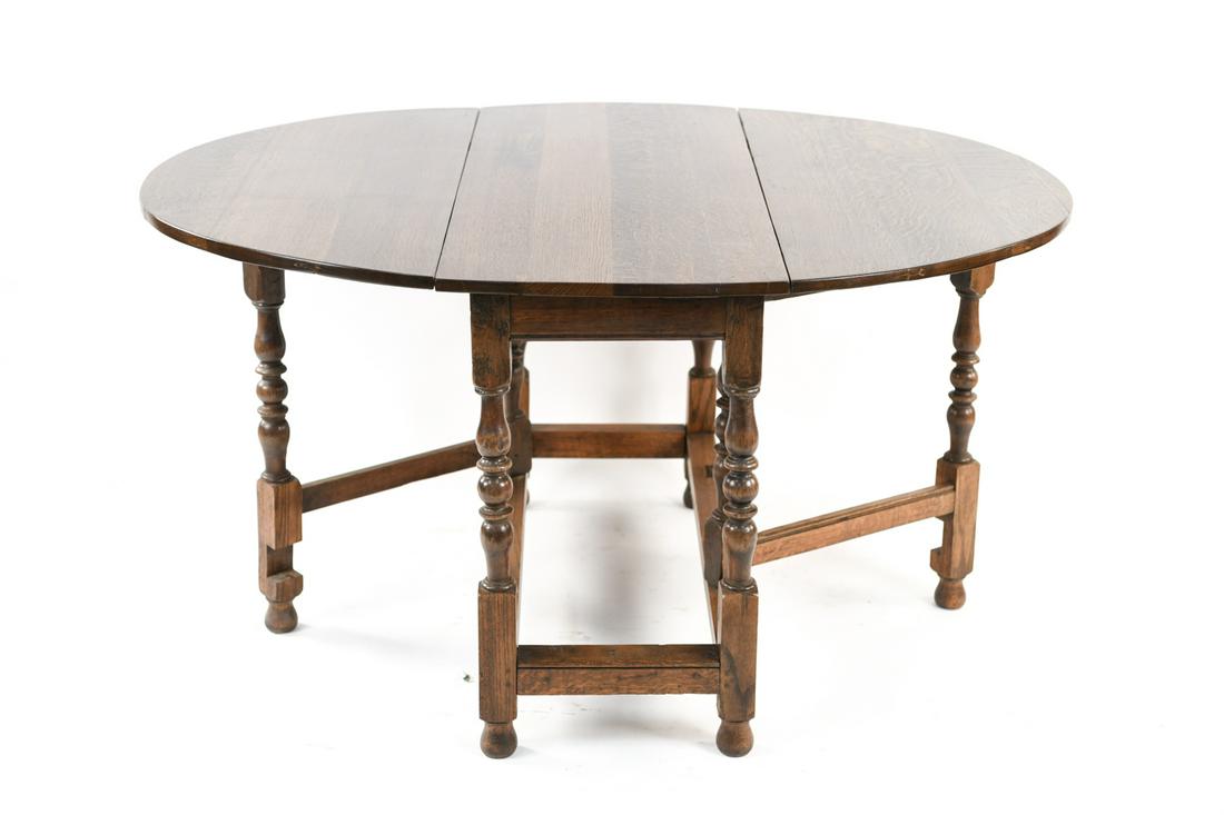 JACOBIAN STYLE OAK DROP LEAF TABLE: Late 19th/early 20th century. Generous size. Turned legs Dimensions: (Open) H 29.25" x W 56" x D 46.5" Condition: Scratch to top. Some wear on legs and base.