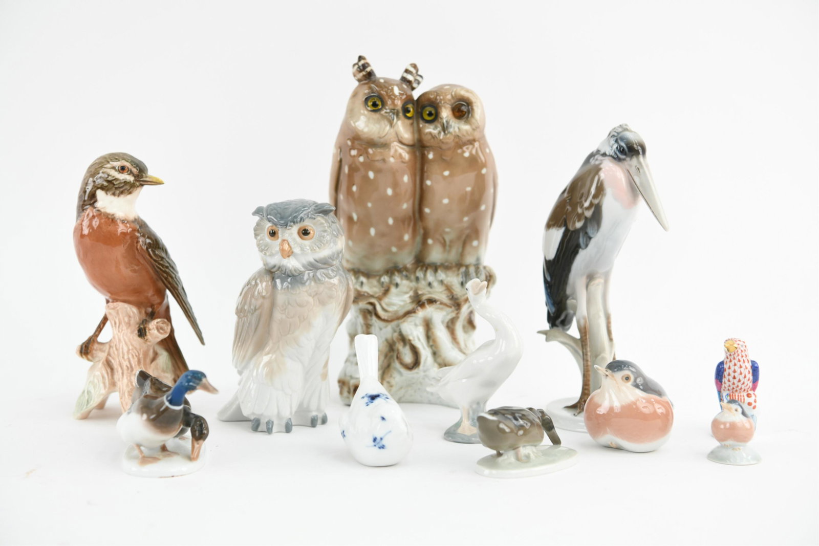 GROUPING OF PORCELAIN BIRDS: Including a small Herend bird, Rosenthal, Lladro, Royal Copenhagen, etc. Dimensions: Largest: H 10.5" x W 5.25" x D 5" Condition: Eye of owl replaced, otherwise no issues to note.