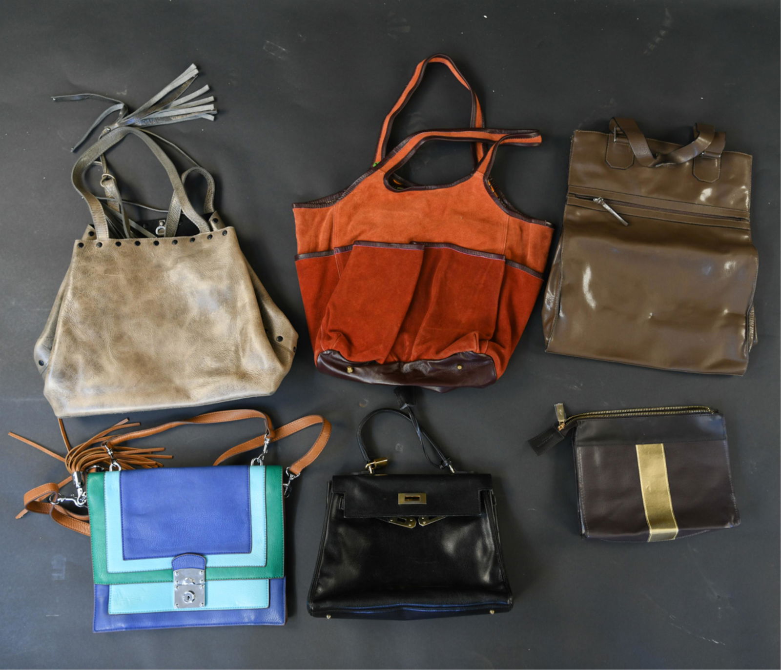 GROUPING OF LEATHER BAGS: (6) bags, all leather or suede, including designers: Calvin Klein, Laggo, Roberta Freymann, Saks Fifth Ave, etc. Dimensions: Laggo: H 15" x W 15" (not including strap) Condition: Showing signs of use.