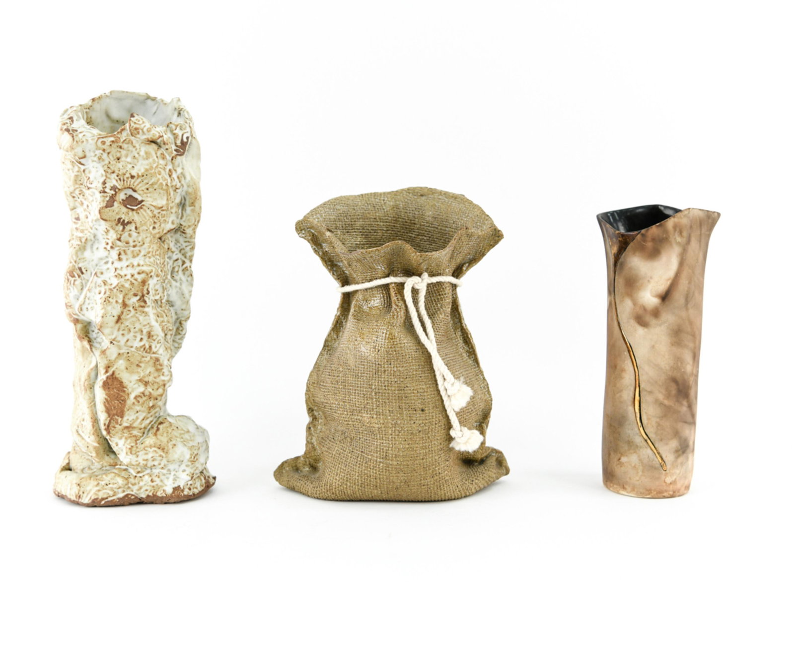 STUDIO CERAMIC GROUPING: Including a burlap sack vase, 1990s abstract face vase signed underneath, and an abstracted studio pottery vase. Dimensions: (Tallest) H 12" x W 5" x D 4" Condition: Minor signs of use.