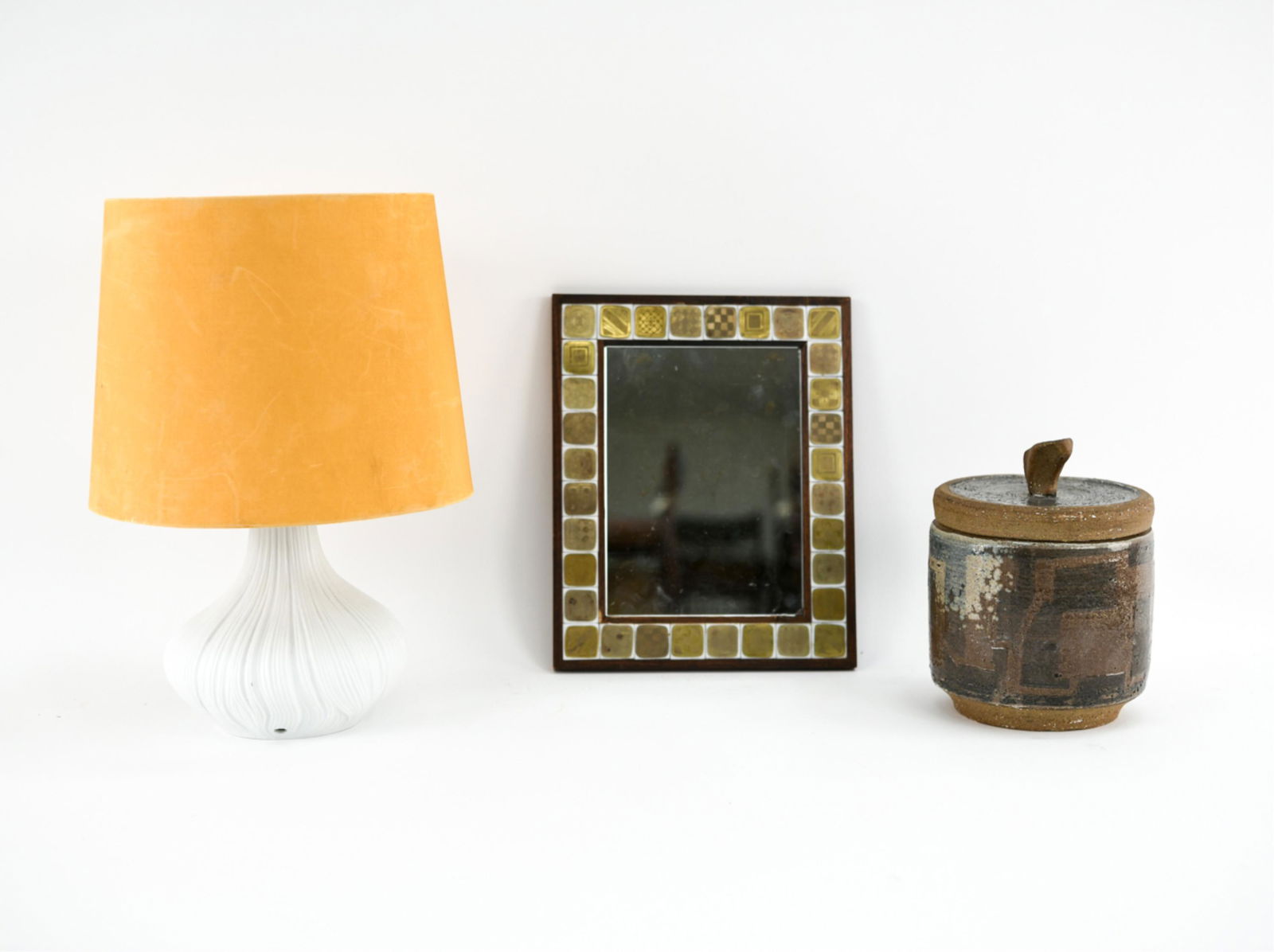MID-CENTURY DECORATIVE GROUPING: Including mid-century studio pottery ice bucket, Rosenthal glass tile and teak mirror, and Rosenthal vase drilled for lamp. Dimensions: (Ice bucket) H 9" x Dia. 6.5" Condition: Lamp not wired. Small l