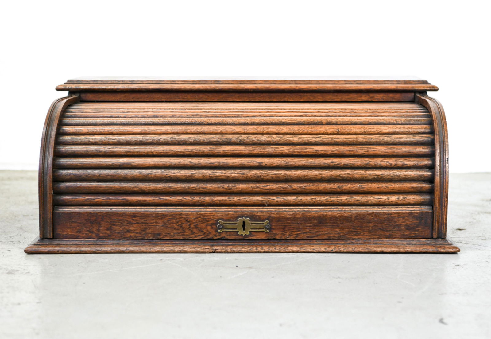 OAK ROLL TOP DESK ORGANIZER: Original antique brass hardware. Moat likely part of a desk at one time. Dimensions: H 11" x W 29.5" x D 18.5" Condition: Rolls nicely. Splits or repair to interior. Staining, scuffs, scratches throug