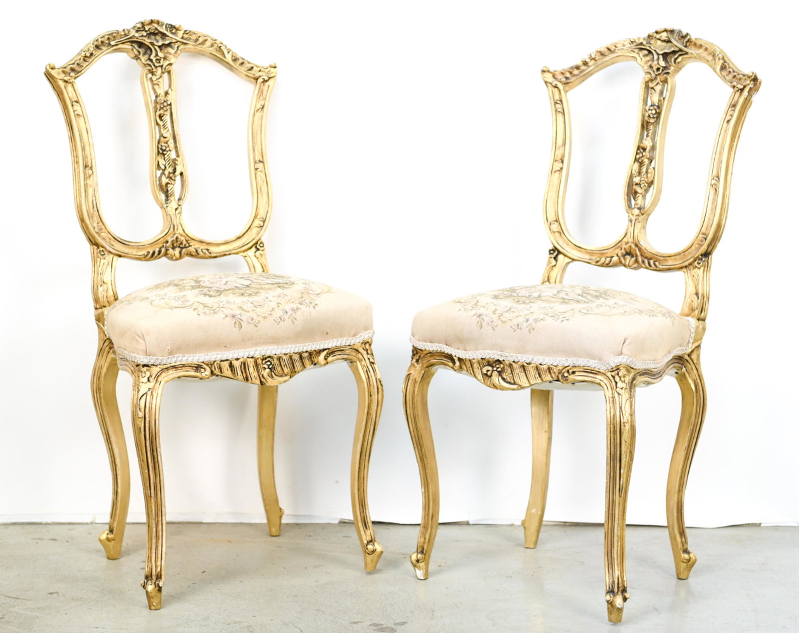 PAIR OF FRENCH GILT & EMBROIDERED SIDE CHAIRS: Antique, carved wood. French Aubusson style upholstered seats. Dimensions: H 36" x W 17" x D 15.5" x SH 18.5" Condition: Repairs and cracks at joints. Losses to gilding.