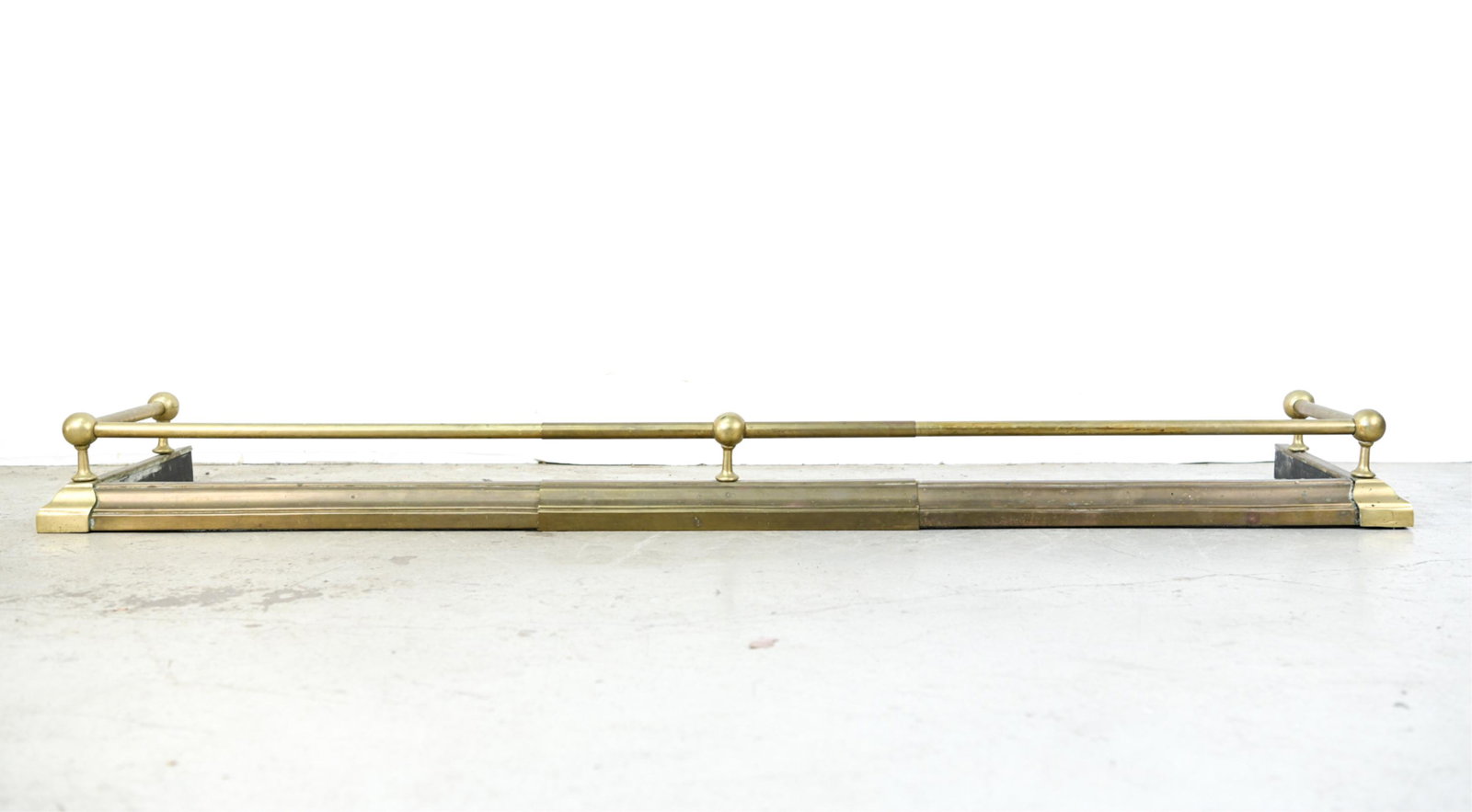 BRASS EXTENDING FIRE FENDER: Dimensions: H 5.5" x W 65.5" x D 16.75" Condition: Signs of use including patina, surface wear.