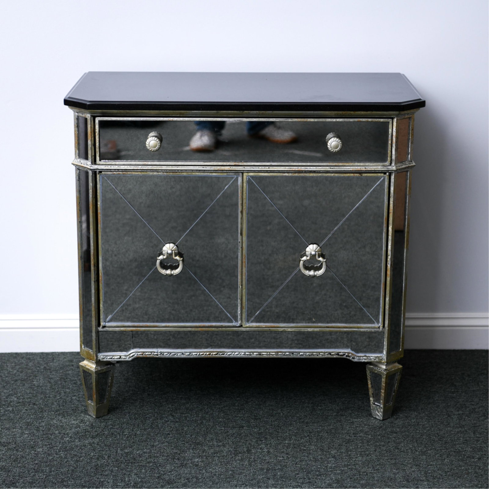 CONTEMPORARY MIRRORED CABINET: With black stone top. Faux antiqued silvered gilding. Dimensions: H 29" x W 30.5" x D 17.25" Condition: No issues to note.