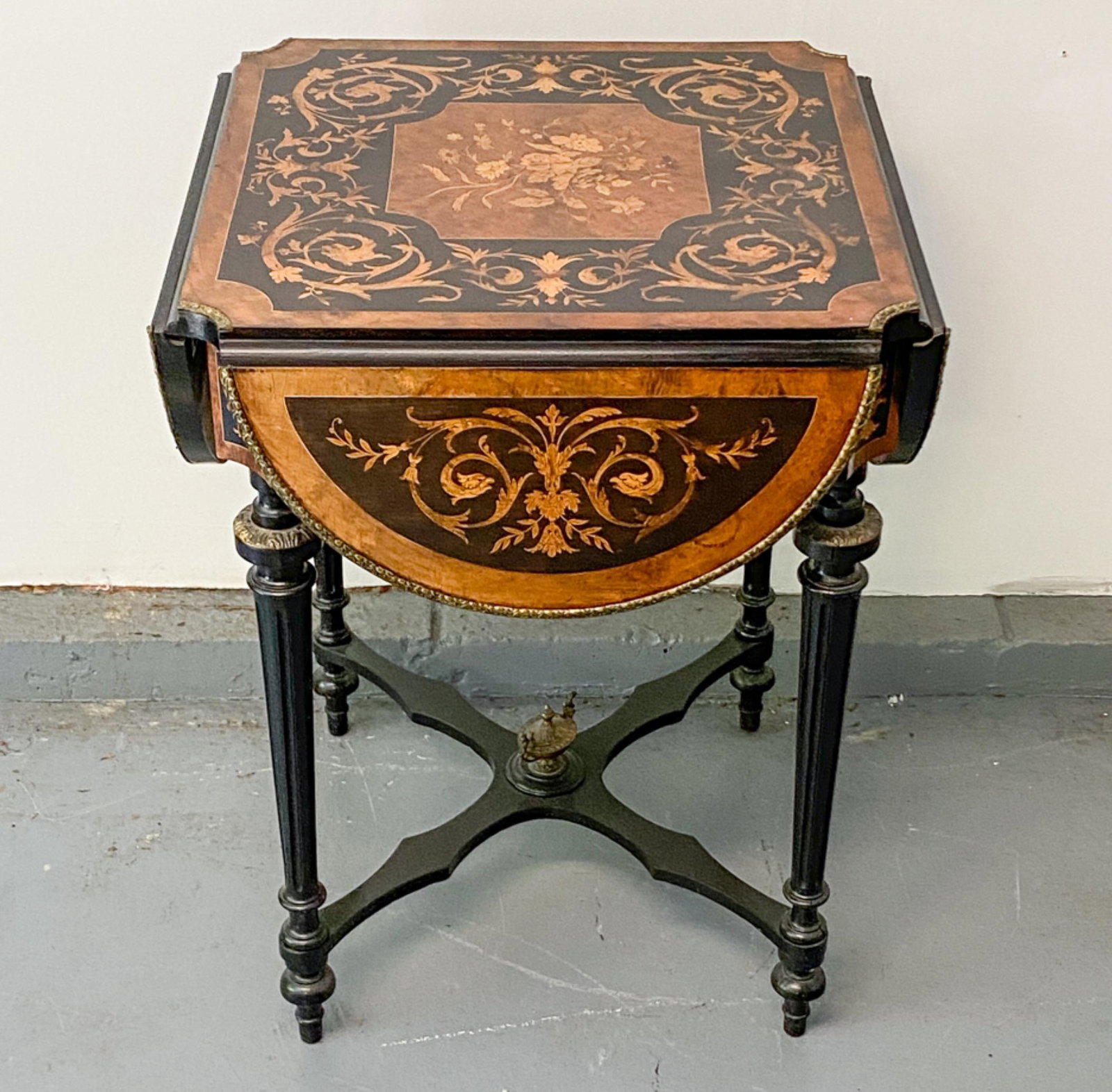 INLAID WOOD AND ORMOLU DROP LEAF GAME TABLE: Dimensions: (Closed) H 29" x W 22.5" x D 22.5" Condition: Wear consistent with age and use.
