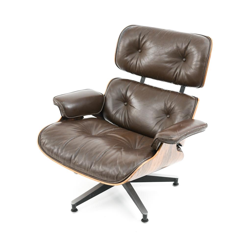 EAMES FOR HERMAN MILLER MODEL 670 LOUNGE CHAIR: Rosewood and brown leather. Label residue underneath, but label lacking. Dimensions: H 33" x W 33" x D 31" x SH 15" Condition: Wear to upholstery consistent with use including discoloration, creasing.