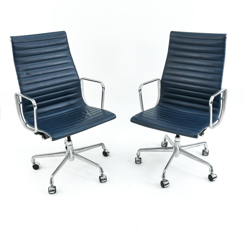 PAIR OF EAMES ALUMINUM GROUP EXECUTIVE CHAIRS: Tagged underneath. Blue upholstery. Dimensions: H 41" x W 23" x D 21" x SH 18.5" Condition: Some rubbing and white paint marks to arms. Couple pen marks to both. Rubs to some edges.