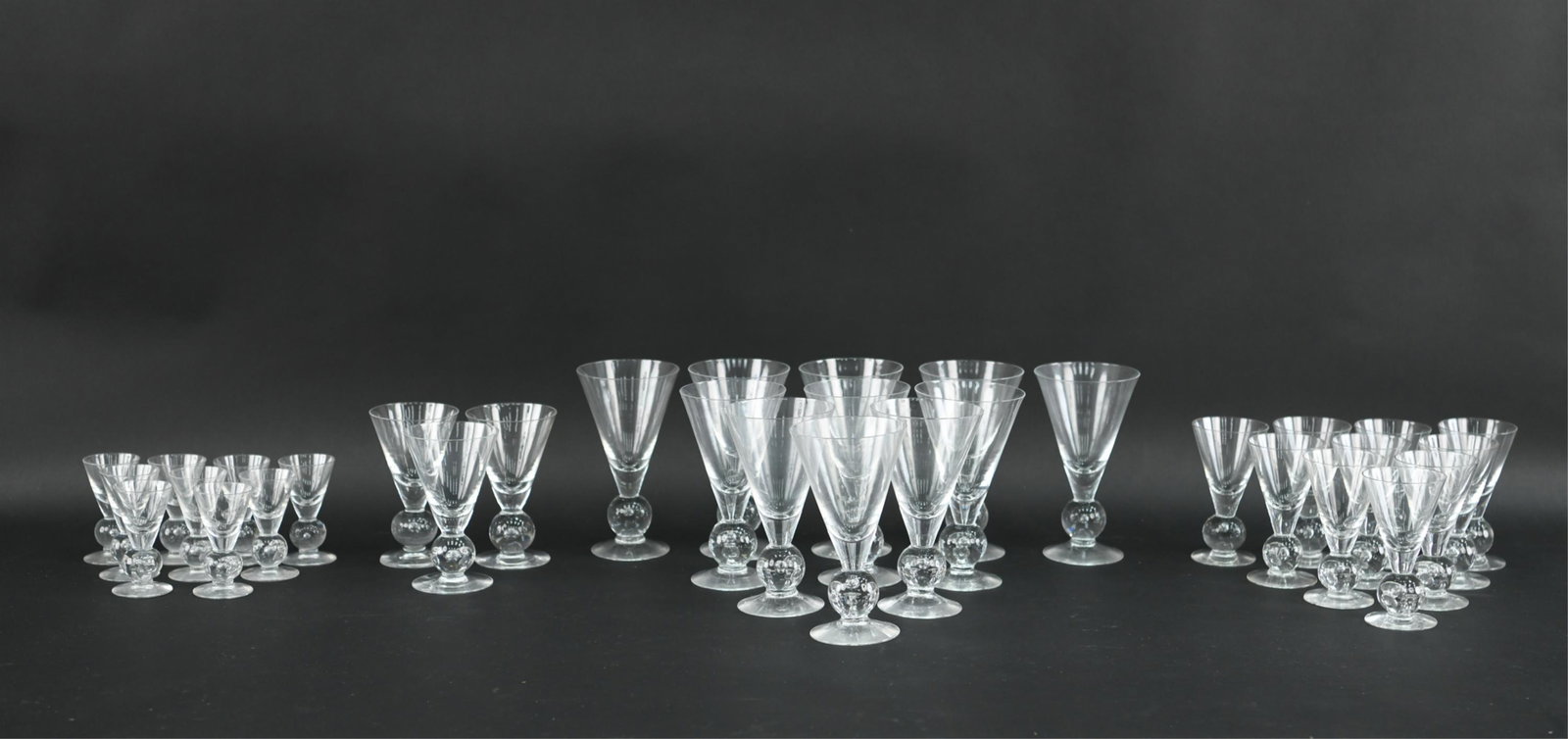 SUSPENDED BUBBLE STEMWARE MANNER OF STEUBEN: Includes: (11) 6.5", (10) 4.75", (3) 5.25", and (9) 3.5". Dimensions: (Tallest) H 6.5" x Dia. 3.75" Condition: Light use wear. Small chip to one tall glass.