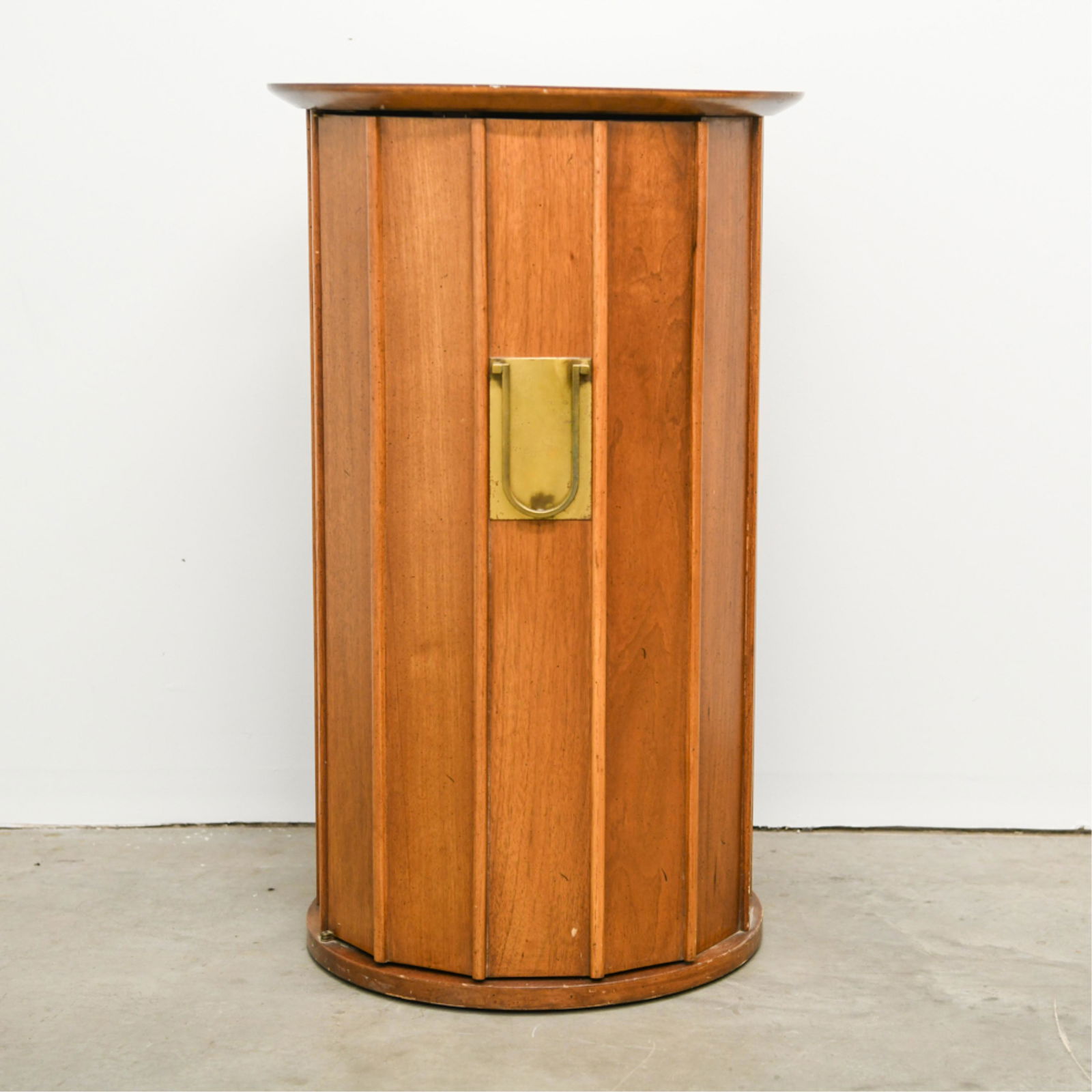 MID-CENTURY PEDESTAL CABINET: Dimensions: H 32.75" x Dia. 19.5" Condition: Couple light surface marks. Few scratches and rubs. Marks to surface of interior shelf.