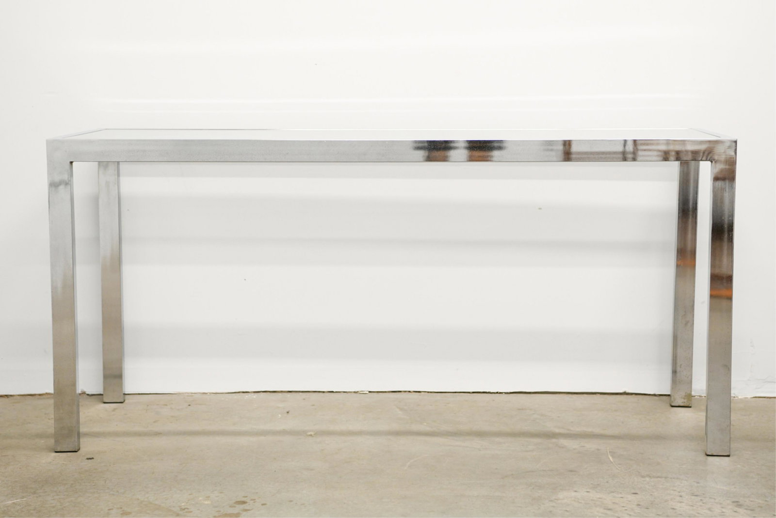 CHROME & GLASS CONSOLE TABLE: Dimensions: H 28" x W 60" x D 19" Condition: Some areas with early pitting, finish wear, and rust to chrome. Surface scratches to glass and chrome.