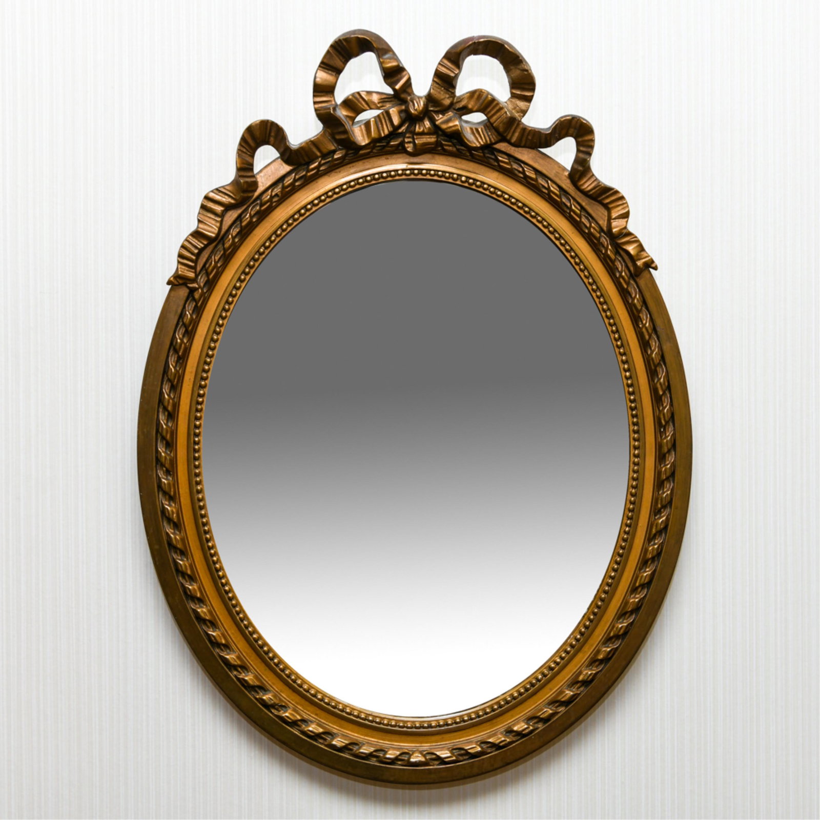 FRENCH STYLE RIBBON MIRROR: Faux antique finish. Beveled glass. Dimensions: H 26" x W 19.25" x D 1.5" Condition: Ribbon broken and repaired.