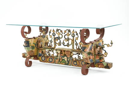 19TH CENTURY SICILIAN WEDDING CART AXLE TABLE: Sculptural base of carved and painted wood panel with decorative iron. Converted into coffee table. Dimensions: H 17" x W 42" x D 18" Condition: Small scallop chip to one corner.