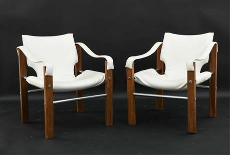 PAIR OF MAURICE BURKE ARKANA SAFARI CHAIRS: Solid teak frames with white vinyl upholstery. Dimensions: H 29.5" x W 22.5" x D 23" x SH 16.5" Condition: Showing signs of use including minor rips, stains and scuffs.