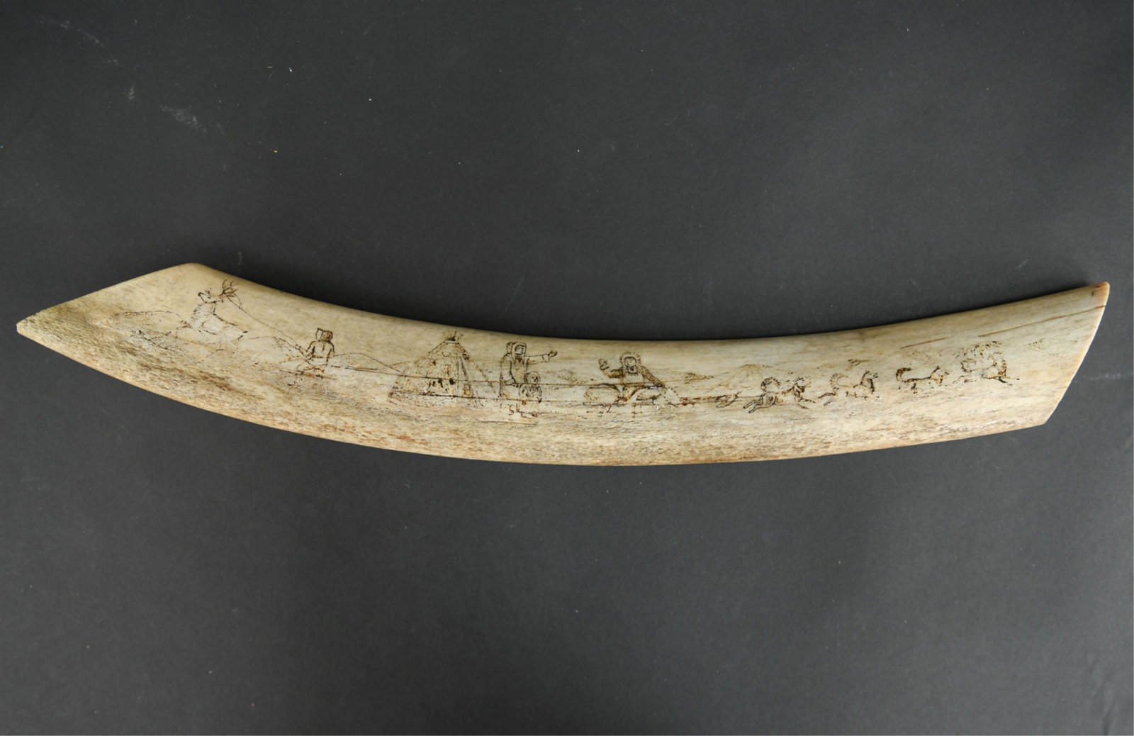 19TH CENTURY INUIT CARVED WHALE BONE: Marked Alaska on back. Carved on both sides. Dimensions: L 20.75" x W 2.5" x D 1.5" Condition: Loss to some of the carving due to age. Minor chips to edges.