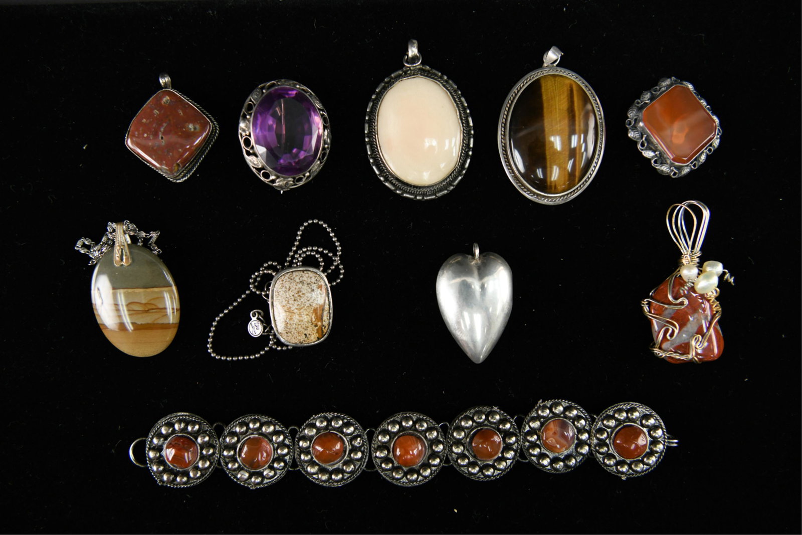 SILVER AND STONE JEWELRY PENDANTS: Sterling silver and natural stones, also including one purple glass stone. Various ages, Mid-Century and earlier. Dimensions: Largest (Tigers eye) H 2.5" x W 1.5" Condition: Showing light signs of use