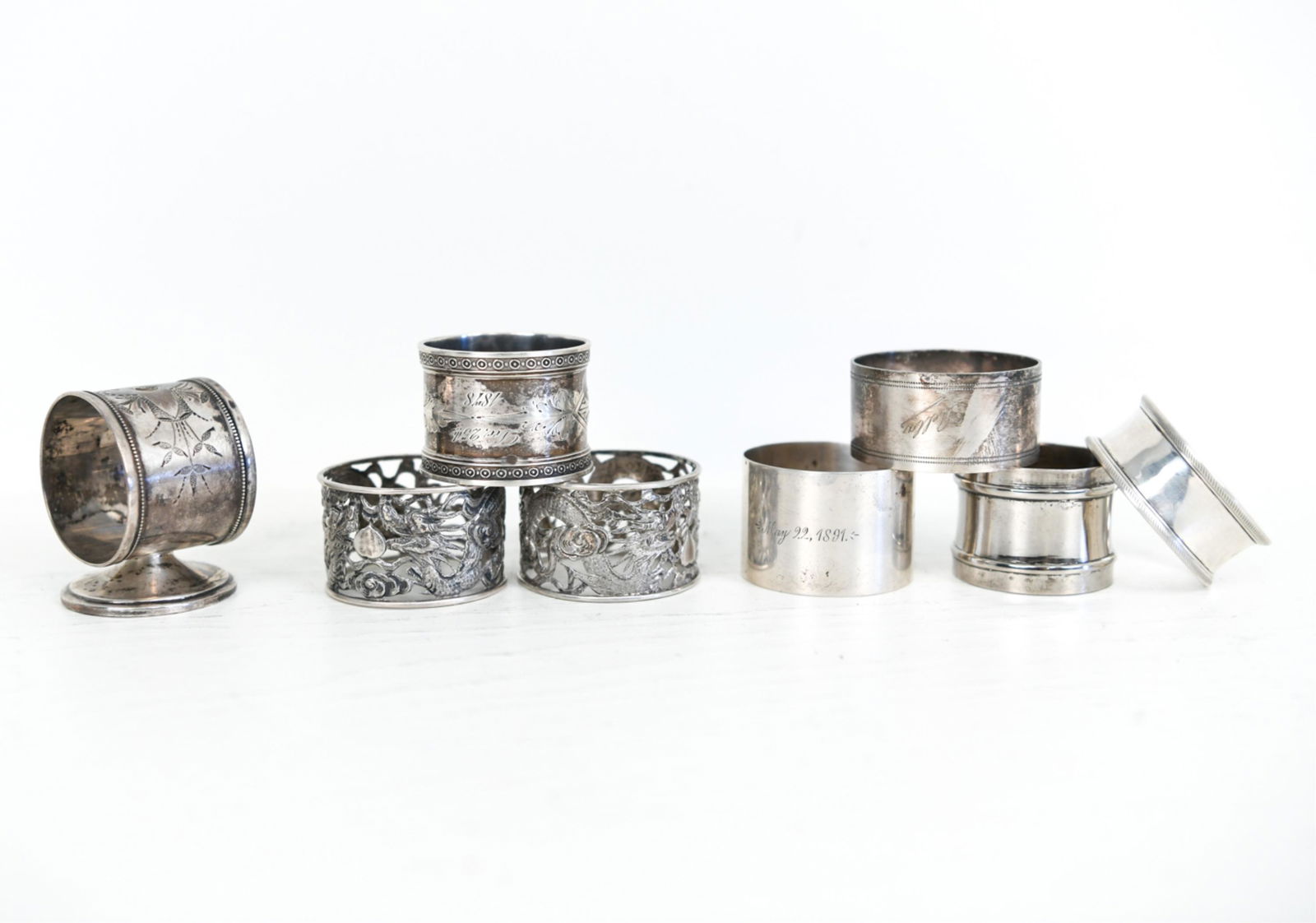 GROUPING OF ANTIQUE NAPKIN RINGS INCL. STERLING: Including some silverplate. Some marked. Different styles. Dimensions: (Largest) H 2.25" x W 1.75" x D 1.75" Weight: (3 Marked rings) 2.970 ozt Condition: Signs of use including tarnish.