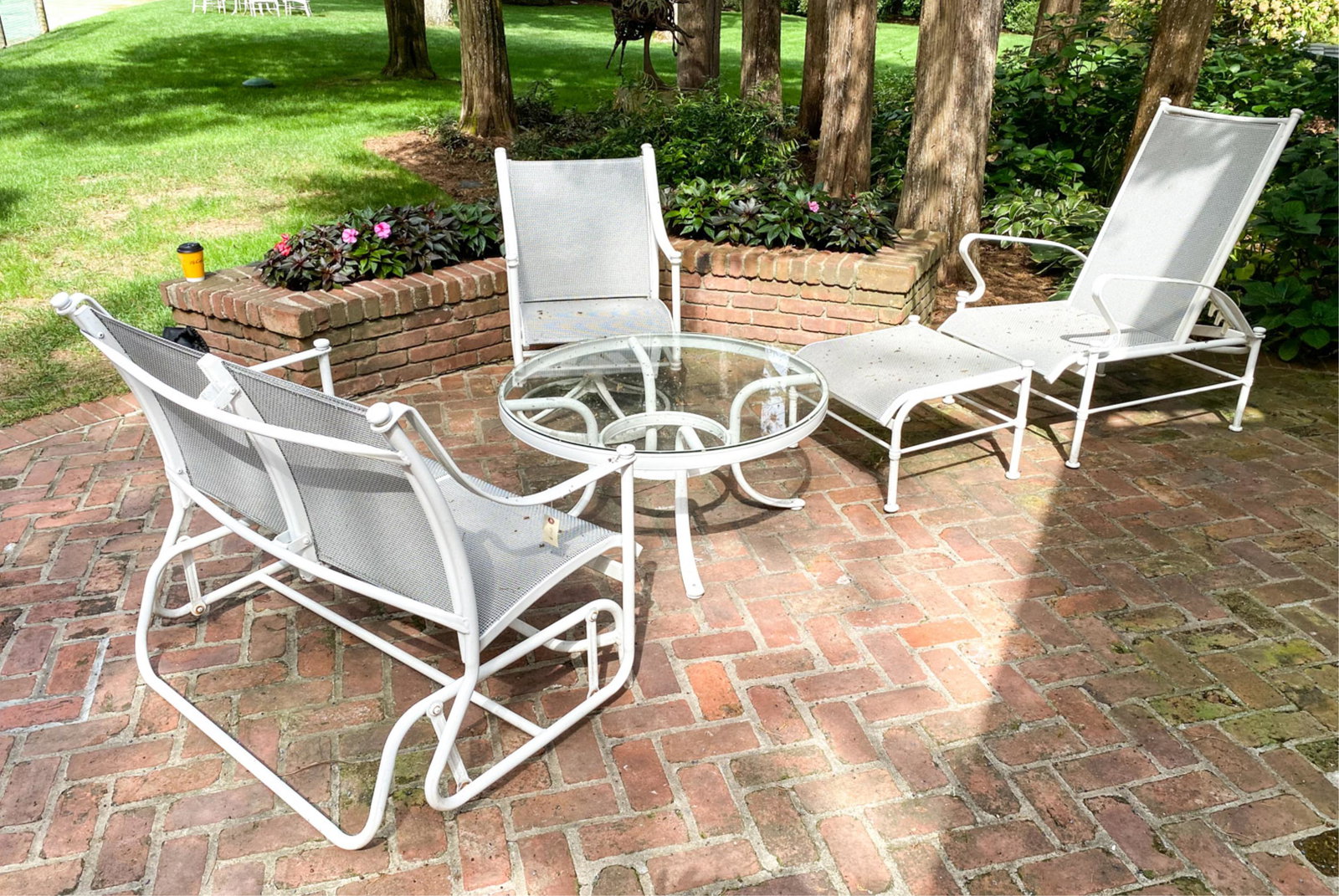 WOODARD OUTDOOR LOUNGE SUITE: including a rocking two seater sofa, a swivel chair and lounge with ottoman Dimensions: (table)H 17.5" x Dia. 36" (sofa) H 36" x W 32" x D 28.5" SH 16" Condition: Showing normal signs of outdoor use i