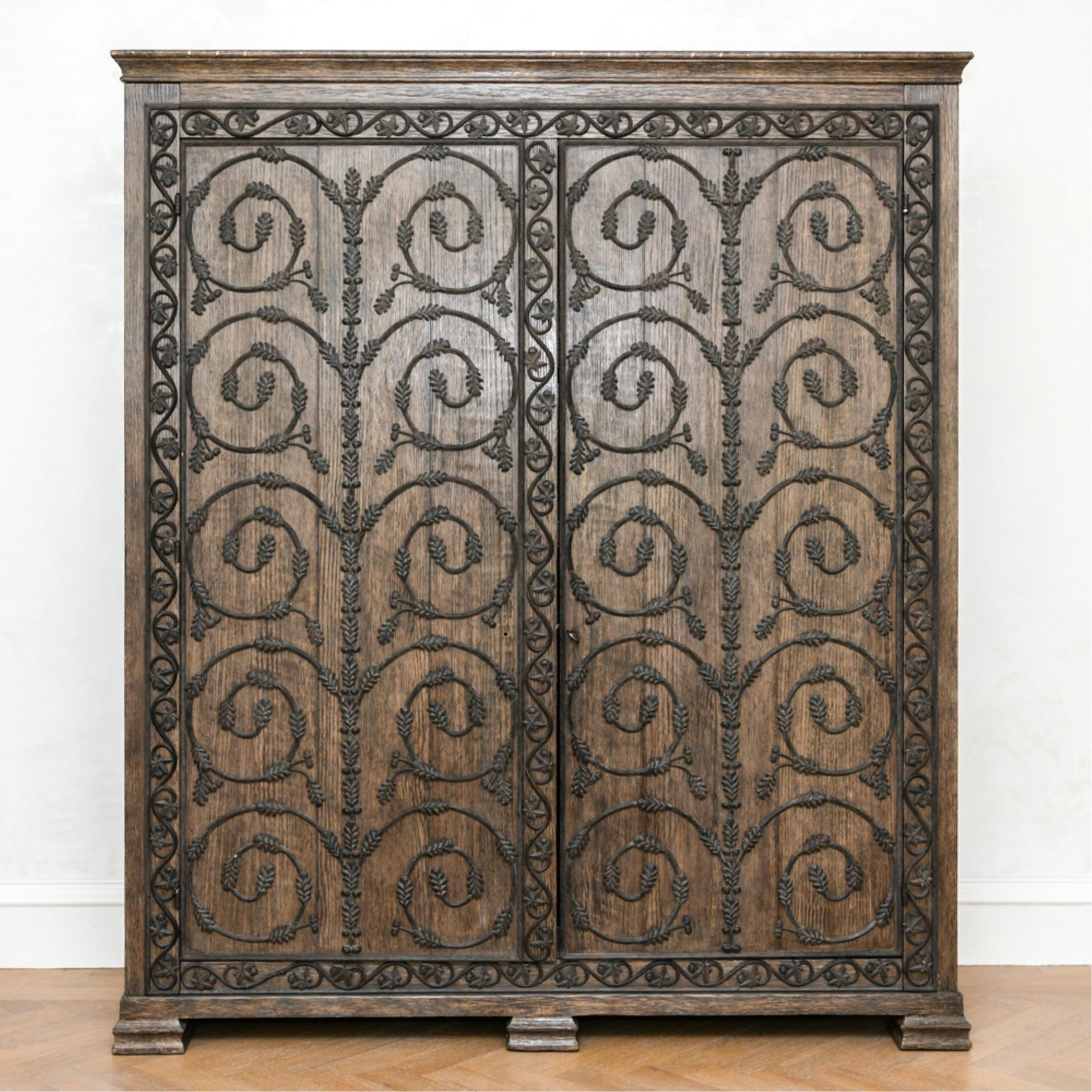 JULIAN CHICHESTER ARMOIRE: Stained oak with iron ormolu mounts. Contemporary, 20th century. Dimensions: H 90" x W 75.5" x D 26.25" Condition: Some scuffs and scrapes to the finish. Overall good. Missing latch for left door. Few