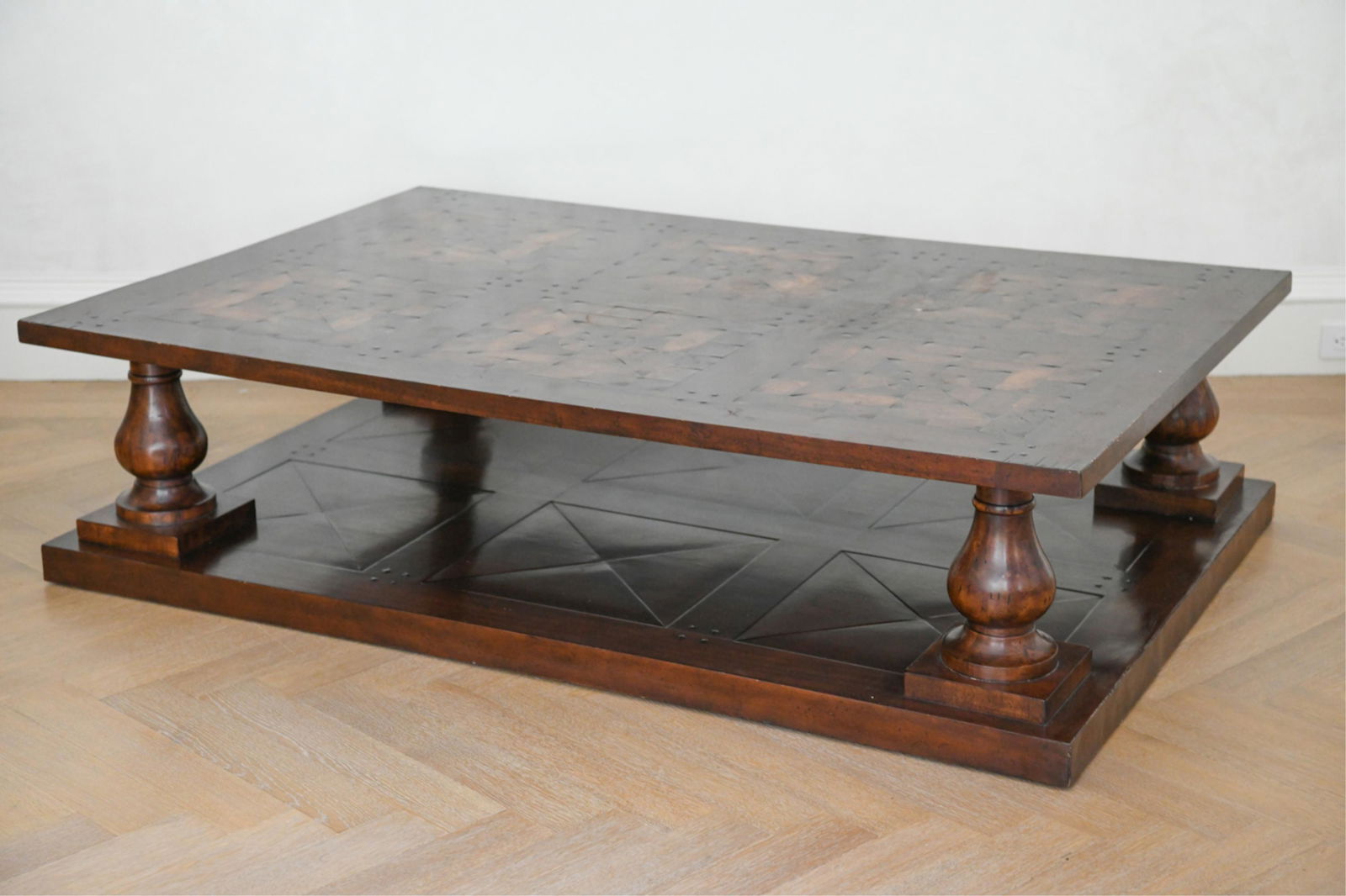 MONUMENTAL PARQUET WOOD COFFEE TABLE: Contemporary, 20th century. Resembling a French parquetry dance floor with baluster columns. Dimensions: H 18.5" x W 71" x D 47" Condition: Wear to finish, minor losses to veneer along bottom edge of