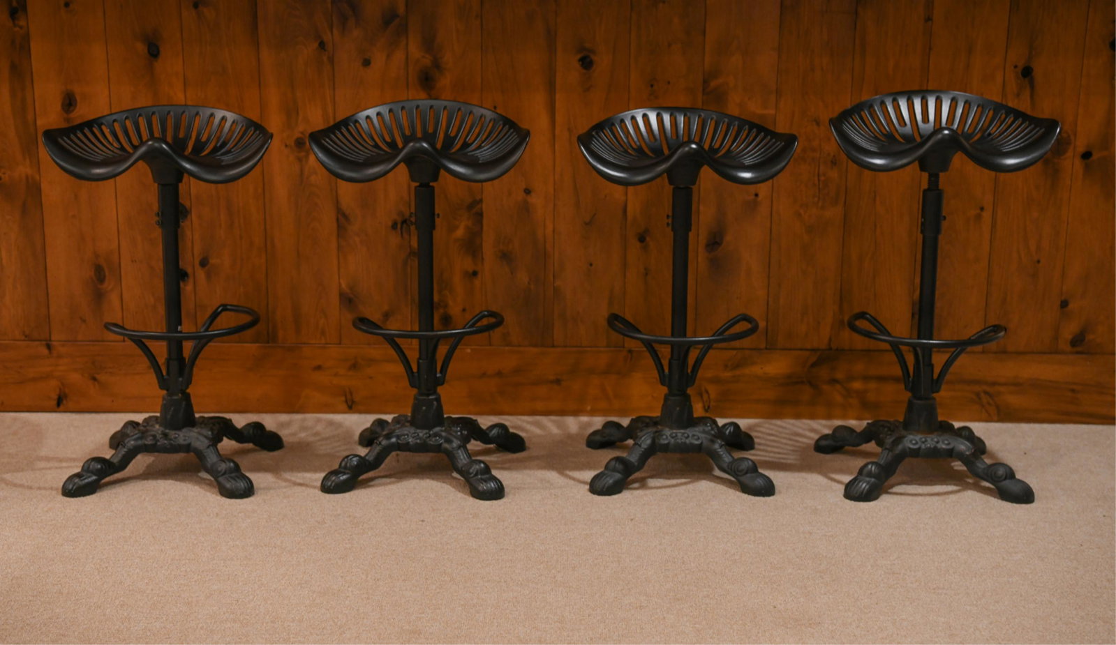FOUR IRON TRACTOR SEAT BAR STOOLS: Heavily cast with new tractor seat style seats and extensions Dimensions: (as photographed) H 29" x W 17" x D 16" SH 27" Condition: Couple spots of rubbing to the finish