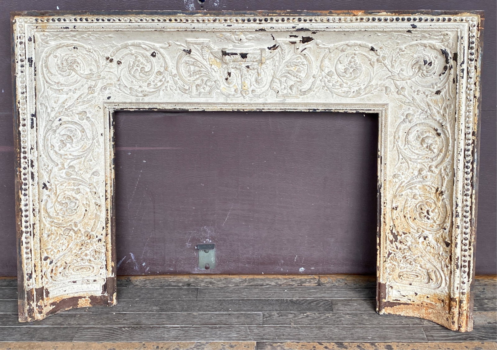 CAST IRON FIREPLACE MANTEL: Dimensions: H 34" x W 48" x D 5" Condition: Wear consistent with age and use including paint flaking and areas of paint loss. Concrete remnants on back of mantel.