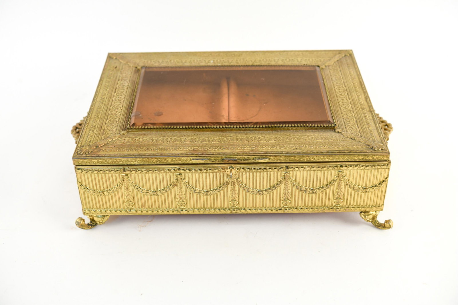 VINTAGE FRENCH STYLE JEWELRY BOX: Dimensions: H 4.5" x W 18" x D 11.75" Condition: Wear consistent with age and use including wax remnants, patina to metal and a chip to glass at one corner with some scratches. Legs appear to be bent 