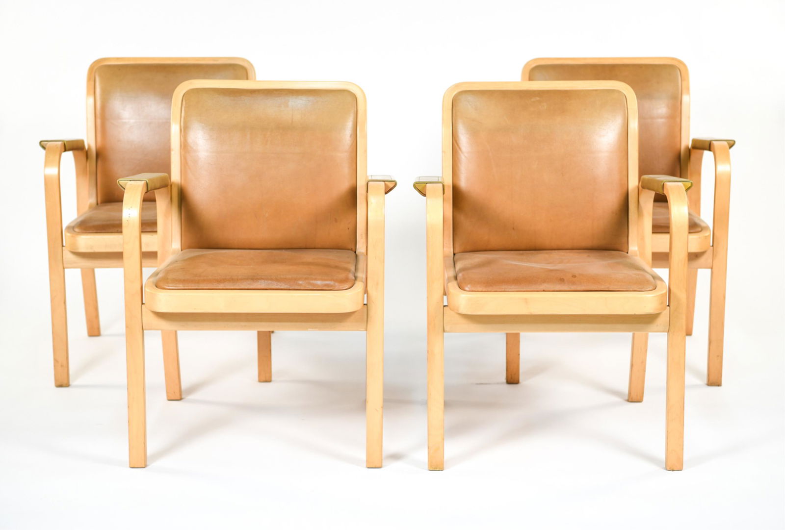 (4) ALVAR AALTO FOR ARTEK ARMCHAIRS: Set of 4 armchairs. Made in Finland. Birch plywood and leather upholstered. Stamped in signature. Dimensions: H 32" x W 24" x D 24" (SH) 18" Condition: Good vintage condition. Frames have scuffs and l