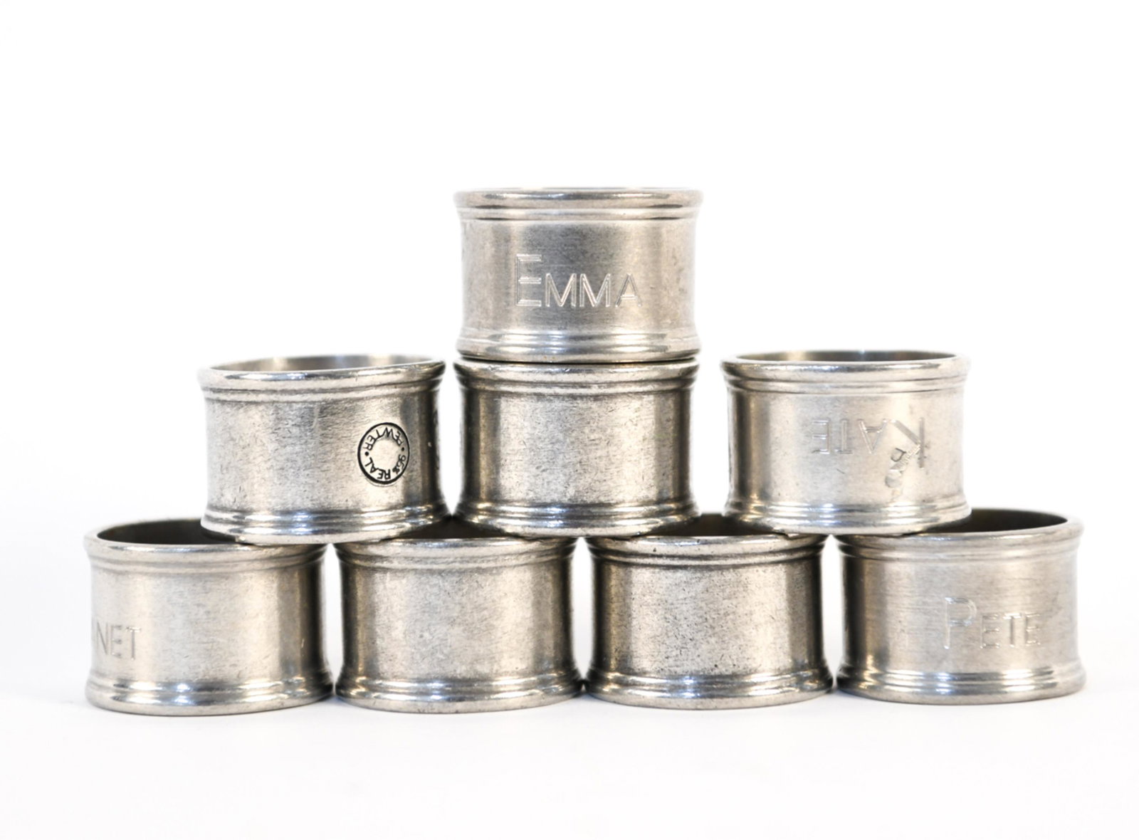 (8) PEWTER NAPKIN RINGS: Marked 95% real pewter. (4) Rings personalized with names. Dimensions: (One ring) H 1.25" x Dia. 1.75" Condition: Wear consistent with use including surface scratches and some tarnishing.