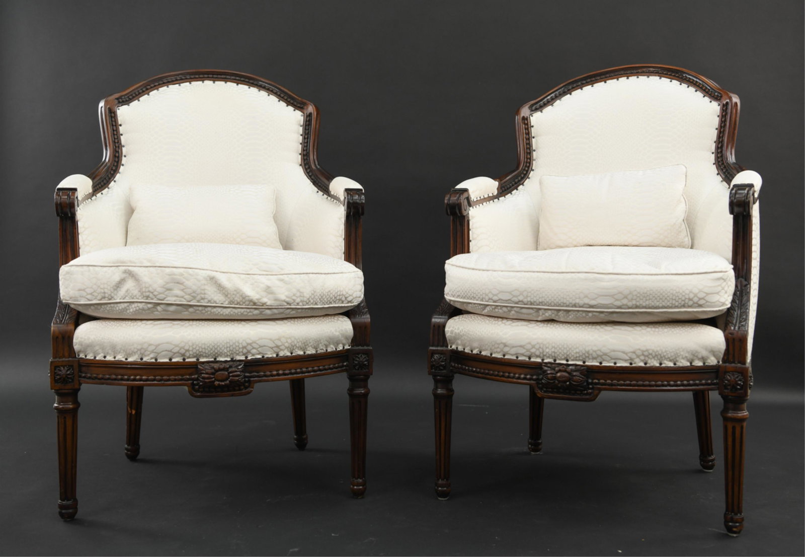 PAIR OF FRENCH STYLE BERGERE CHAIRS: Upholstery with faux reptile skin pattern. Dimensions: H 36.5" x W 24" x D 20" x SH 18" Condition: Break repair to proper right back leg of one. Nicks and marks consistent with use. Light wear to upho